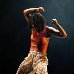 Image shows a black woman dancing passionately