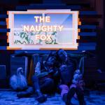The image shows two women fallen asleep with dimmed lights and a sign that says &#039;The Naughty Fox&#039;