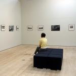 Person sitting in gallery looking at Darren Nesbit exhibition