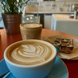 A cup of coffee with a slice of cake